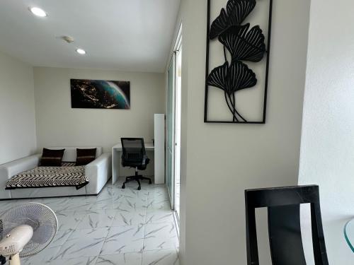 una sala de estar con un sofá y una silla en Phuket Kathu Pluscondo 37 74, en Kathu