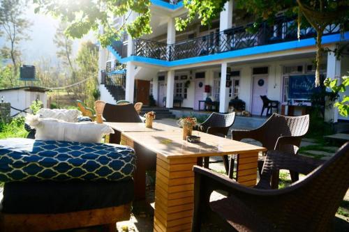 a wooden table and chairs in front of a house at La Hostelgia in Manāli
