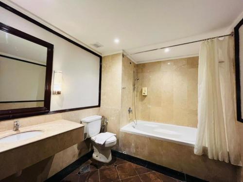 a bathroom with a tub and a toilet and a sink at Kingston Hotel 9 - Jonker Street Malacca in Kampong Morten
