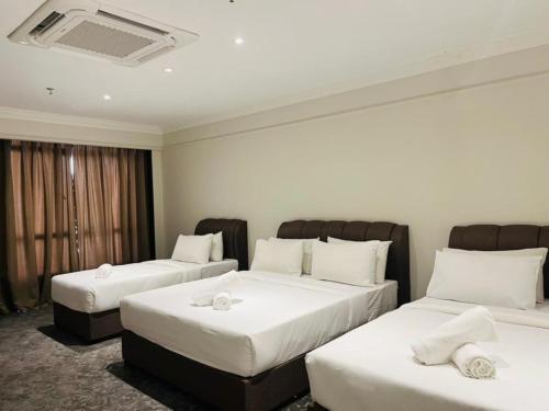 a hotel room with two beds with white sheets at Kingston Hotel 9 - Jonker Street Malacca in Kampong Morten