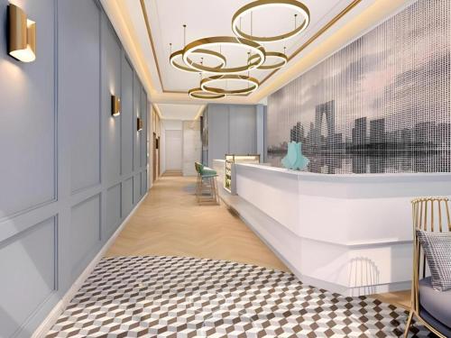 a hallway with a staircase with a chandelier at Magnotel Hotel Suzhou Guanqian Street Pingjiang Road in Suzhou