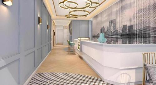 a hallway with chairs and a chandelier at Magnotel Hotel Suzhou Guanqian Street Pingjiang Road in Suzhou
