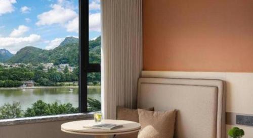 a table and a window with a view of a river at Immersing Hotel Guilin Two Rivers and Four Lakes Dongxi Alley in Guilin