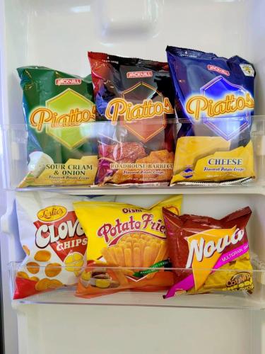 a refrigerator filled with different types of snacks at THE IVORY STAYCATION suite at Hope Residences Trece Martires Cavite in Bitangan