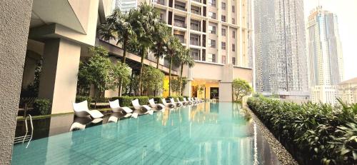a swimming pool with lounge chairs and a building at The Mews KLCC By Service Apartment in Kuala Lumpur