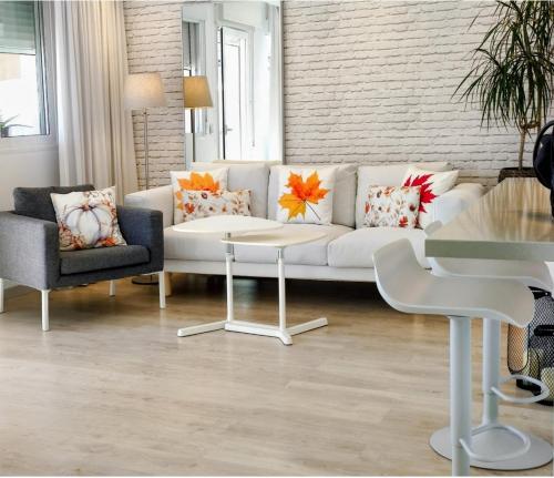 a living room with a white couch and a table at Casa Fuerte Playa in La Herradura