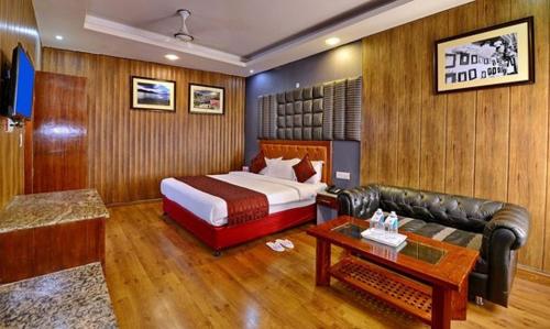a hotel room with a bed and a couch at Hotel Mayur by RoomsInc Katra in Katra