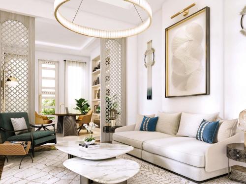 a living room with a white couch and a chandelier at Raffles Al Areen Palace Bahrain in Manama
