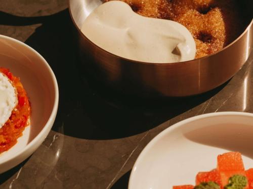 a bowl of dip and a bowl of food on a table at Raffles Al Areen Palace Bahrain in Manama