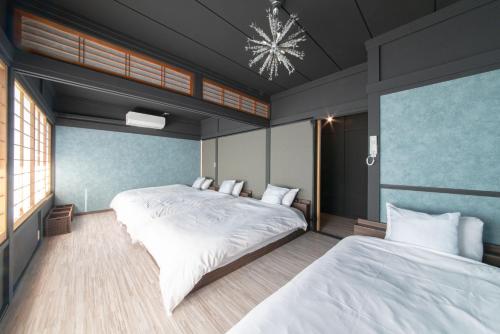 a bedroom with two beds and a chandelier at 瑠璃色の地球 in Katsuura