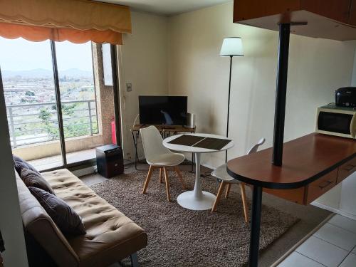 a living room with a couch and a table at Apartamento 1 dormitorio estacionamiento Hermosa vista in Concepción