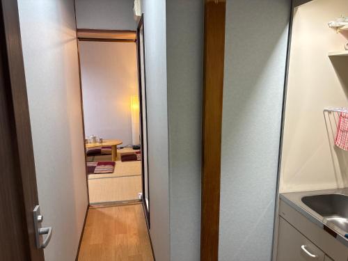 a door to a bathroom with a sink and a mirror at hostel sunflower202 in Osaka