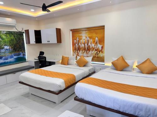 two beds in a room with a kitchen at Hotel Aurora Bliss in Hyderabad