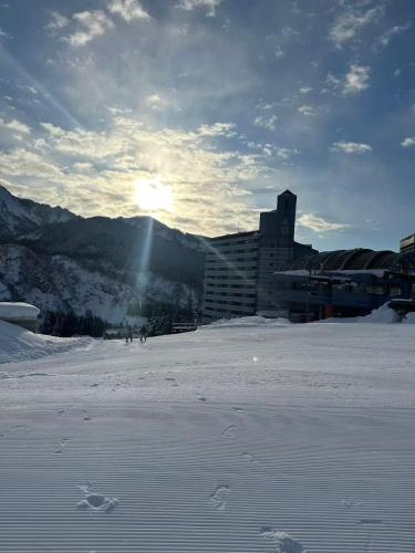 a snow covered field with the sun in the background at Yuzawa YUKITORA 雪虎 in Minami Uonuma