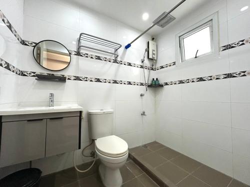 a bathroom with a toilet and a sink and a mirror at Touristation @ Crowne Bay Tower in Manila