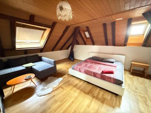 a bedroom with a bed and a couch at Rooms for rent in Bolligen in Bolligen