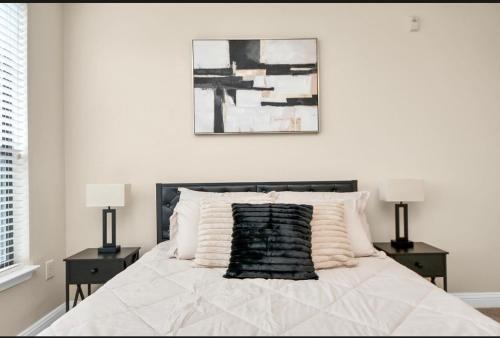 a white bedroom with a bed with two night stands at Luxury Estate in Houston