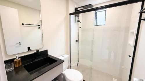 um banheiro com box de vidro e vaso sanitário em ASA | Loft UP 309 | Lado da FURB | Oktoberfest em Blumenau