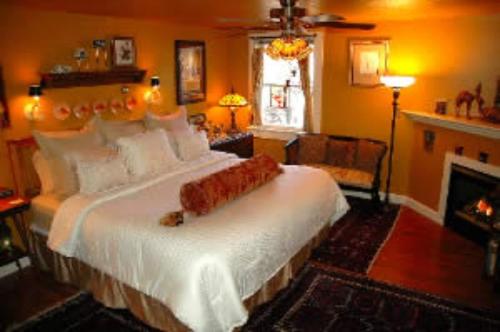 a bedroom with a large bed and a fireplace at Red Elephant Inn Bed and Breakfast in North Conway