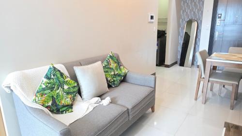 a living room with a couch and a dining room at BGC Hotel Vibe with City View at Uptown Parksuites near St Luke's, Grand Hyatt Hotel, Uptown Mall, and Mitsukoshi Mall in Sampong