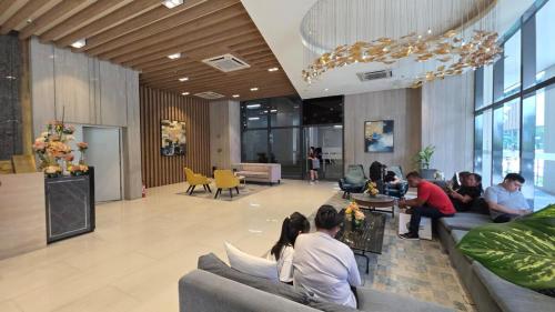 a group of people sitting on couches in a lobby at BGC Hotel Vibe with City View at Uptown Parksuites near St Luke's, Grand Hyatt Hotel, Uptown Mall, and Mitsukoshi Mall in Sampong