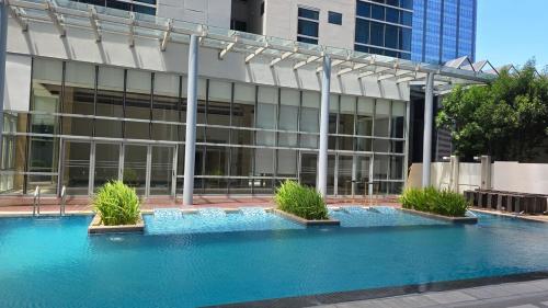 a building with a swimming pool in front of a building at BGC Hotel Vibe with City View at Uptown Parksuites near St Luke's, Grand Hyatt Hotel, Uptown Mall, and Mitsukoshi Mall in Sampong