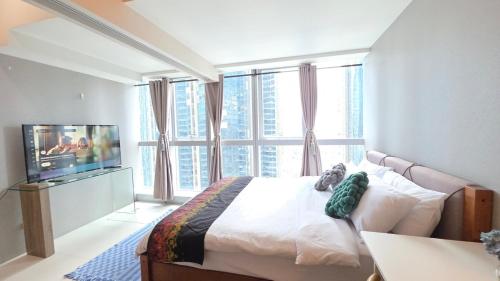 a bedroom with a bed and a large window at BGC Hotel Vibe with City View at Uptown Parksuites near St Luke's, Grand Hyatt Hotel, Uptown Mall, and Mitsukoshi Mall in Sampong