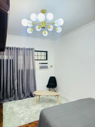 a bedroom with a ceiling fan and a table at Matthews Home Cebu-Casa Dos in Cebu City
