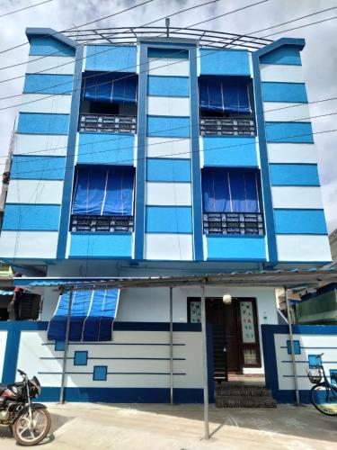 a blue building with windows and a motorcycle parked in front at Sri Dattatreya Nivas in Pithāpuram