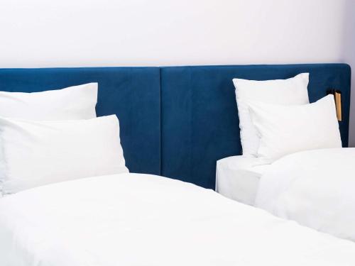 two beds with white pillows sitting next to each other at TRIBE Riga City Centre in Rīga