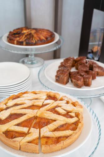 a pie on a table with three plates of food at Melia Venezia Lido in Venice-Lido