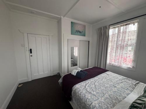 a bedroom with a bed and a window at Shazza Homestay in Invercargill