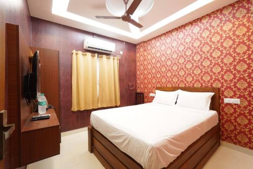 Un dormitorio con una cama y un ventilador de techo. en Easwarresidency, en Chennai