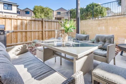 a patio with a table and chairs and a fence at Yallingup Lagoon Beach House in Yallingup