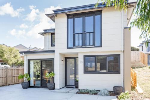 a white house with black windows and doors at Yallingup Lagoon Beach House in Yallingup