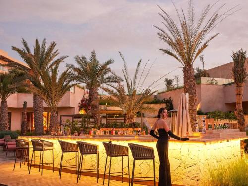 a woman standing in front of a pool at a resort at Fairmont Taghazout Bay in Taghazout