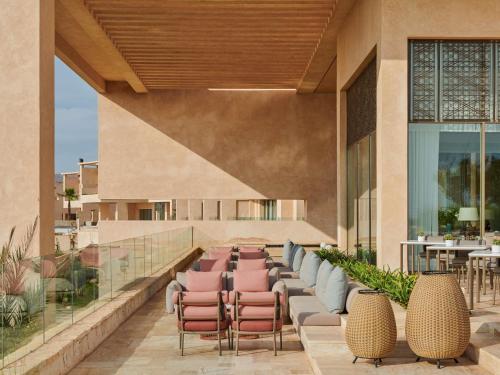 a patio with chairs and tables on a building at Fairmont Taghazout Bay in Taghazout