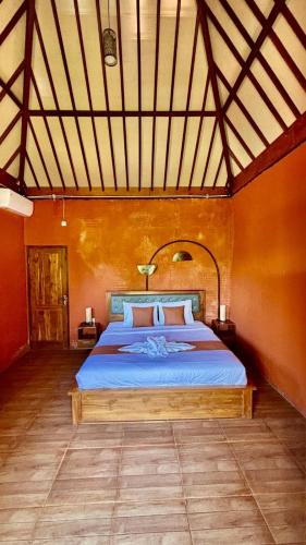 a bedroom with a large bed in a room at Casa Komala Uluwatu in Uluwatu