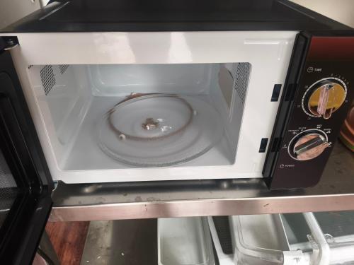 eine Mikrowelle mit einer Schüssel darin in der Unterkunft Vybe Hostel in Bangalore