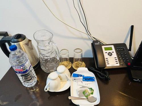 a table with a phone and a bottle of water at Amelia Resort in Sigiriya