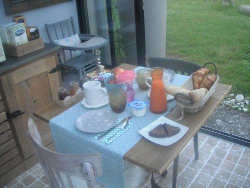 a table with a blue table cloth and food on it at Le Brame - Chambres d'Hôtes in Avilly-Saint-Léonard