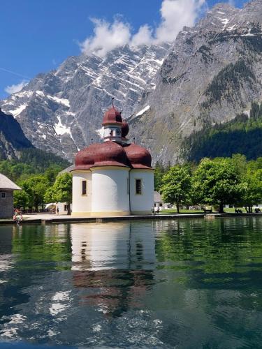a building on the water with a mountain in the background at Ferienwohnung Manuela in Adnet