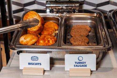 a tray of donuts on a counter in a store at Holiday Inn Express Maspeth by IHG in Queens