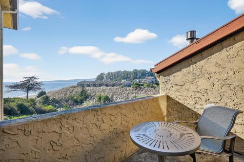 a table and chair on a balcony with a view of the ocean at Luxury Ocean View Condo - Heated pool and Spa condo in La Selva Beach