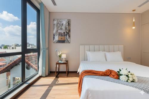 a bedroom with a bed and a large window at Margaery Boutique Apartment & Skyon9 Rooftop Bar in Hanoi