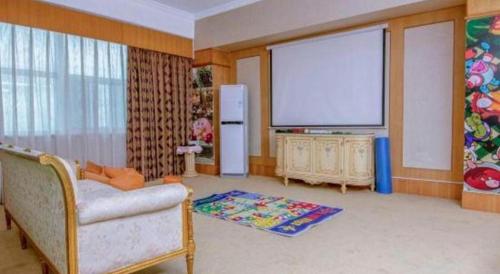 a living room with a large flat screen tv at Zhuhai Dehan Hotel in Zhuhai