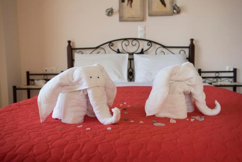 two stuffed elephants are sitting on a bed at Villa Tapia in Methoni