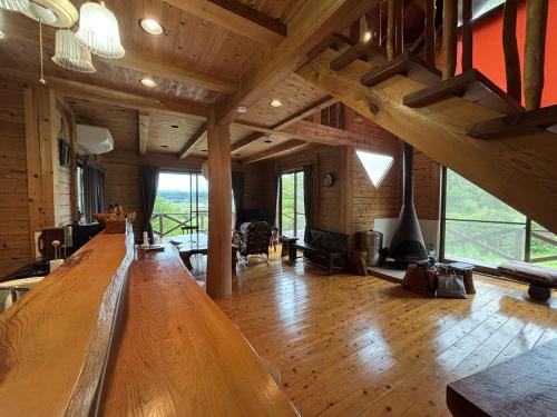 a large living room with a large wooden table at あそびゅう池沢 in Aso