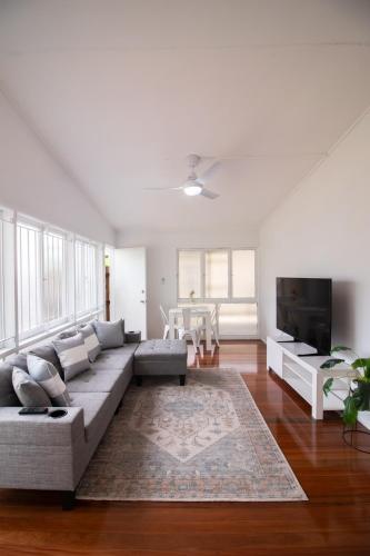 a living room with a couch and a flat screen tv at Entire New renovated 2bedrm unit next to southbank in Brisbane