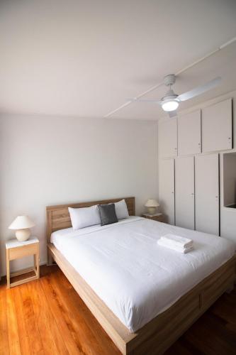 a bedroom with a large white bed with white cabinets at Entire New renovated 2bedrm unit next to southbank in Brisbane